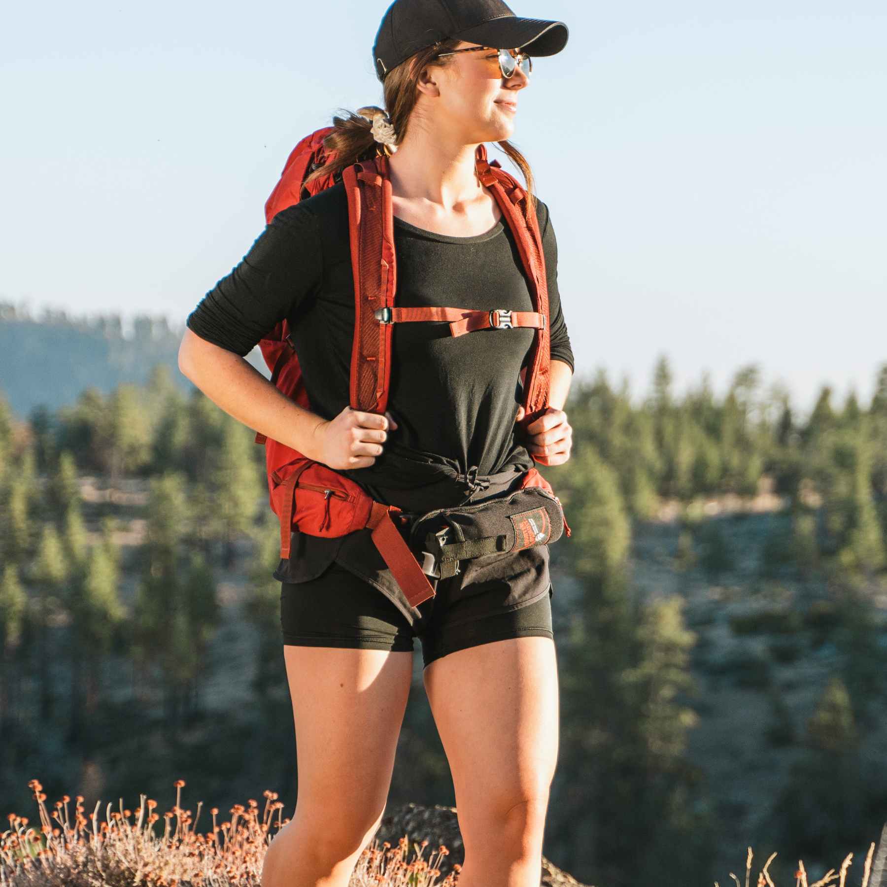 Woman with a bear spray holster attached to bag