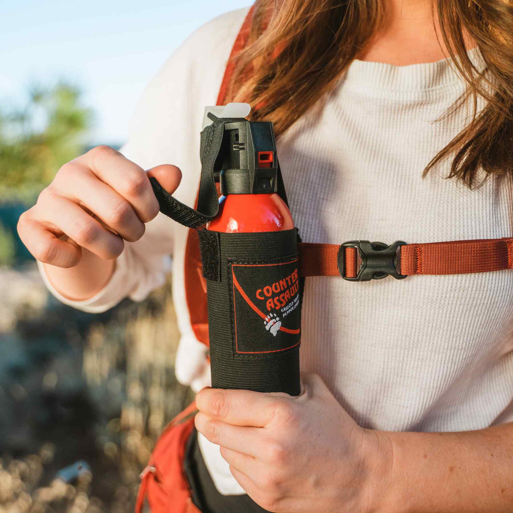 Woman getting the bear spray from the holster