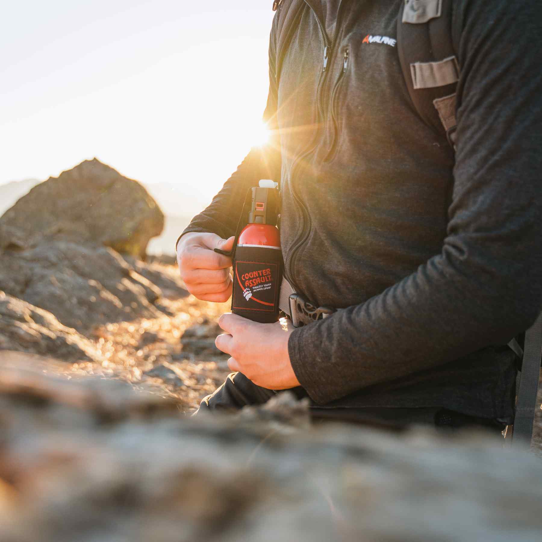 Man putting a bear spray to the universal belt holster