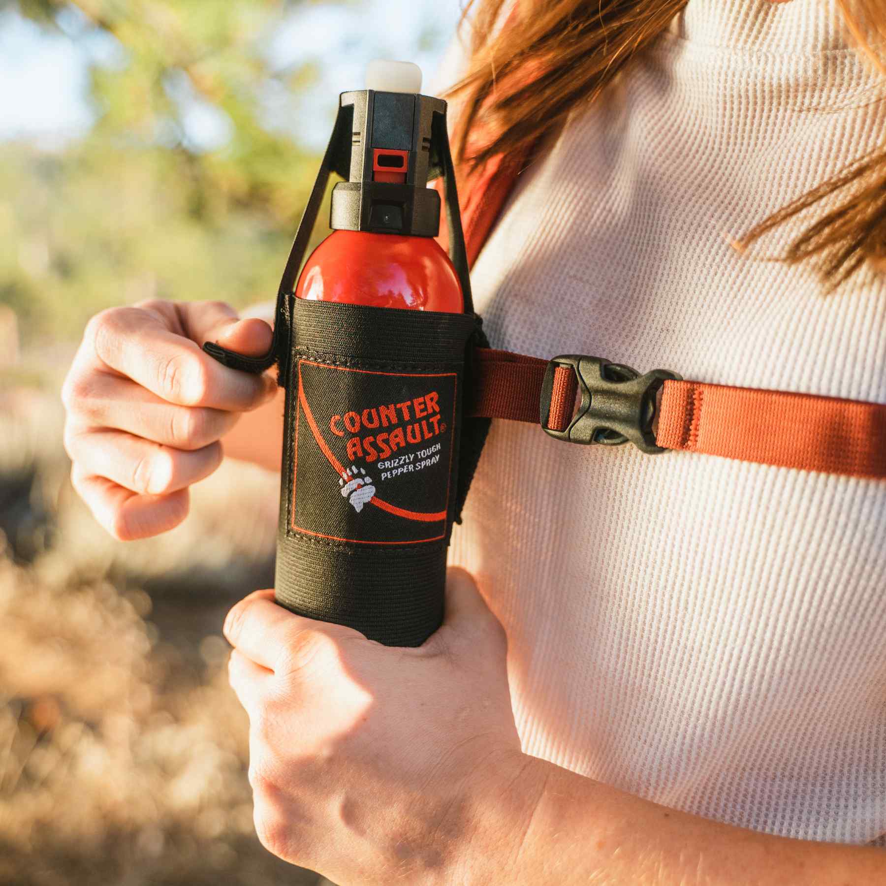 Woman getting the bear spray from the universal belt holster