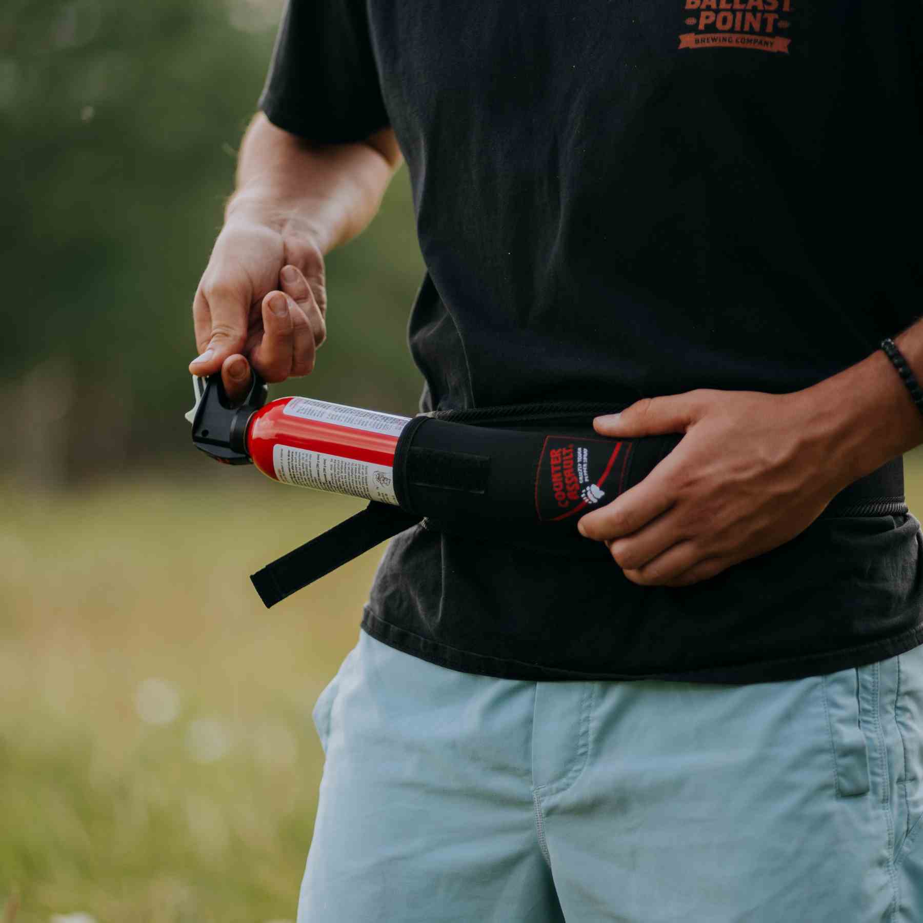 Man putting a bear spray to a trail runner holster