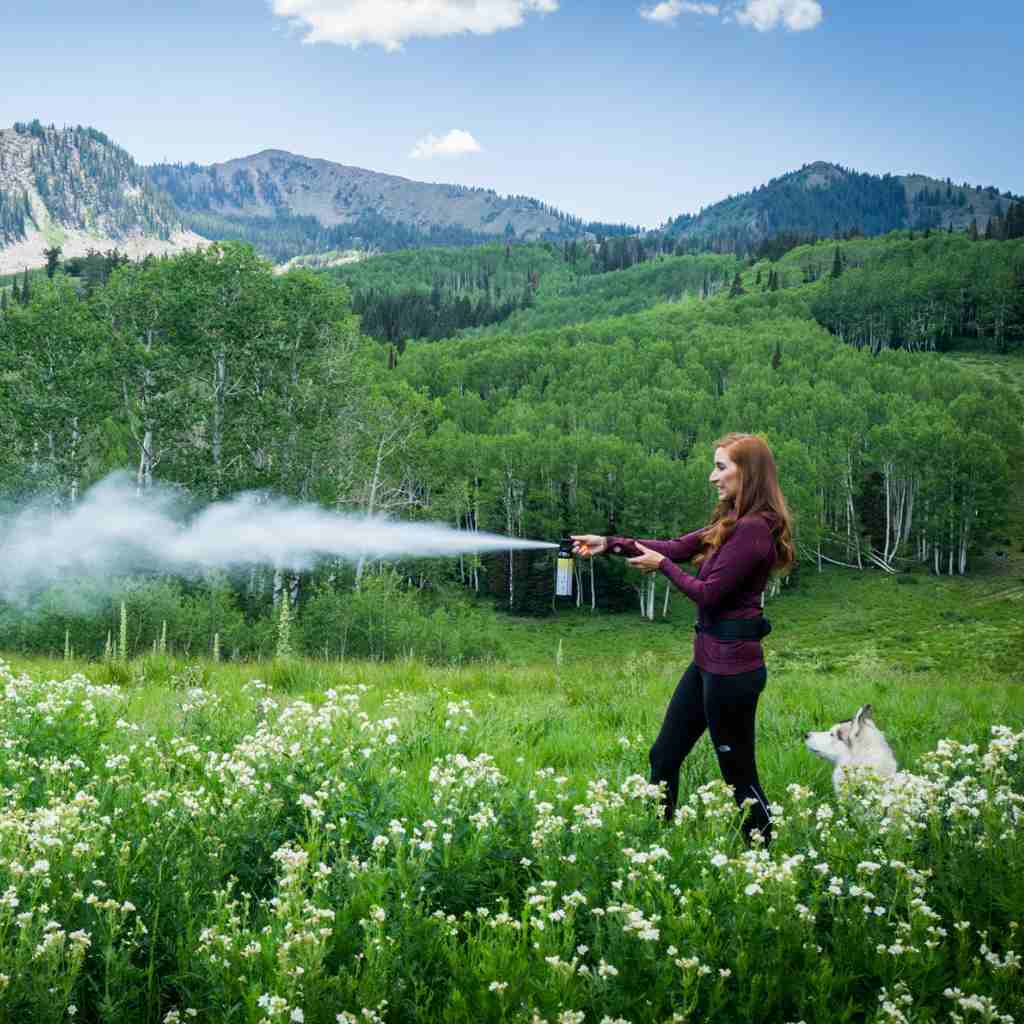 Woman using inert training canister in a field.