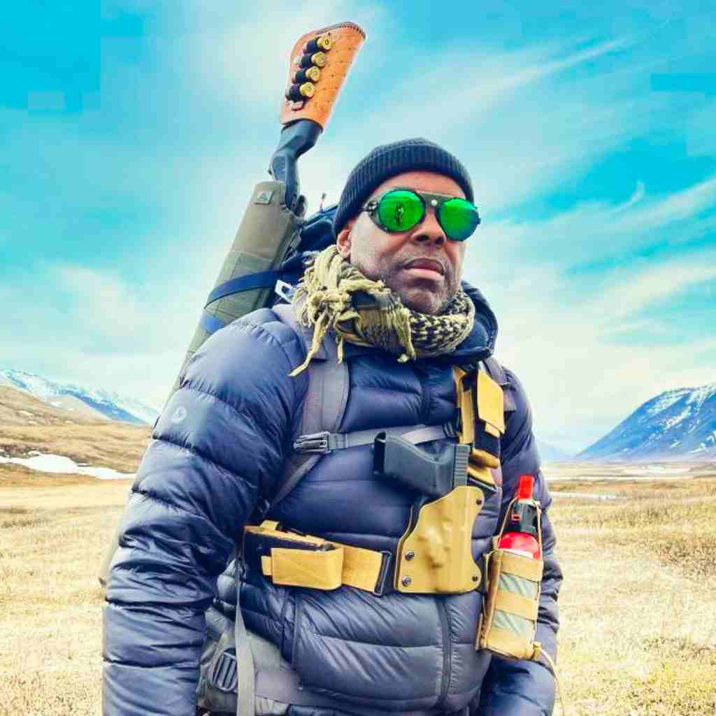 Man with winter clothing with bear spray strapped to chest.