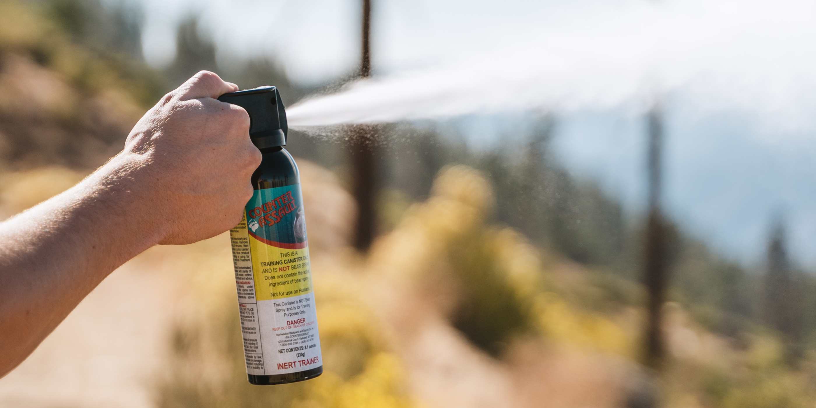 Person spraying inert training canister