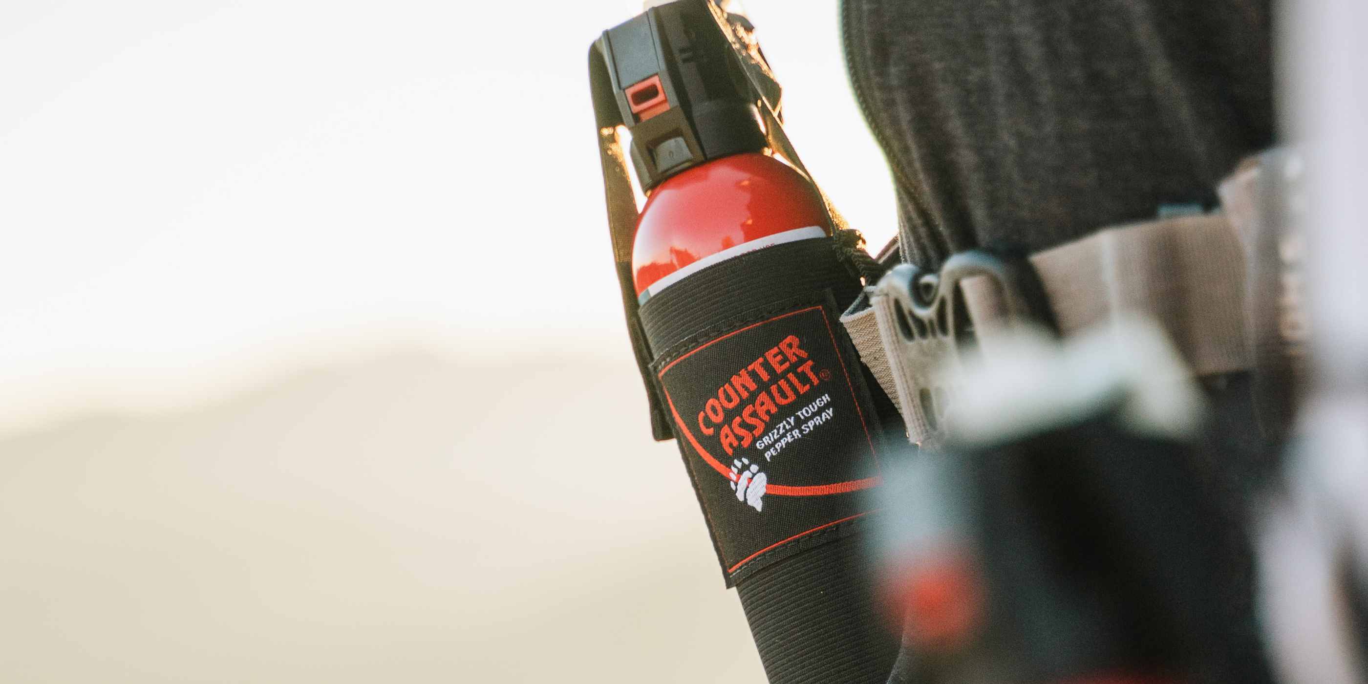 Belt holster with bear spray attached to front of person