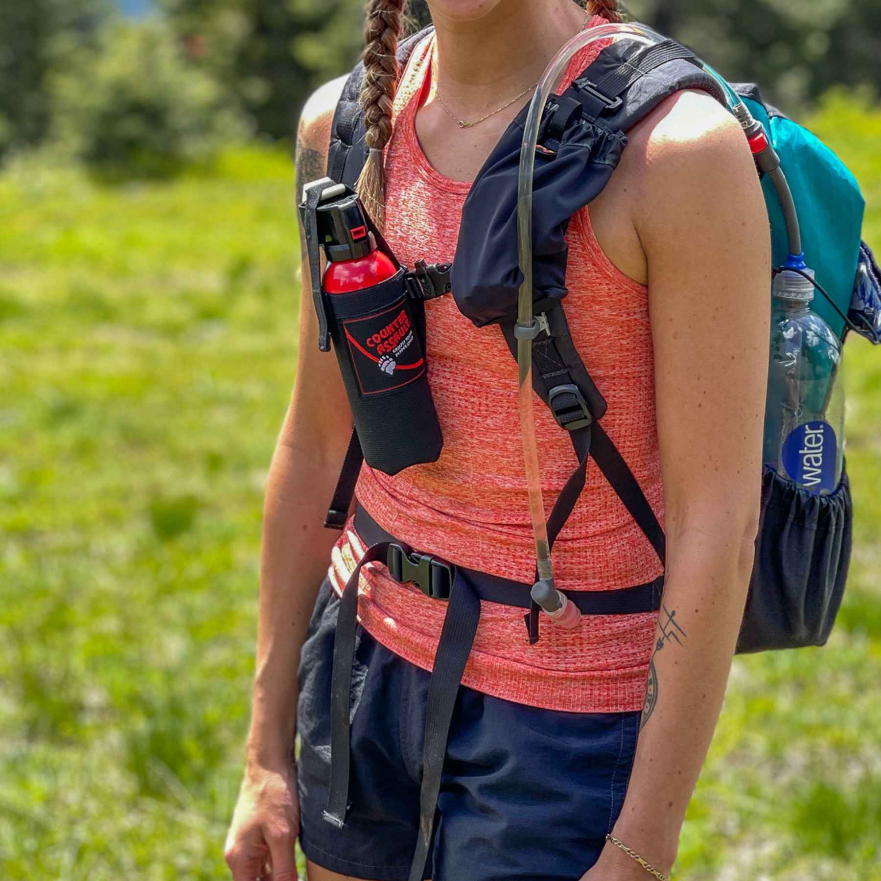 Woman hiker with bear spray strapped to chest.