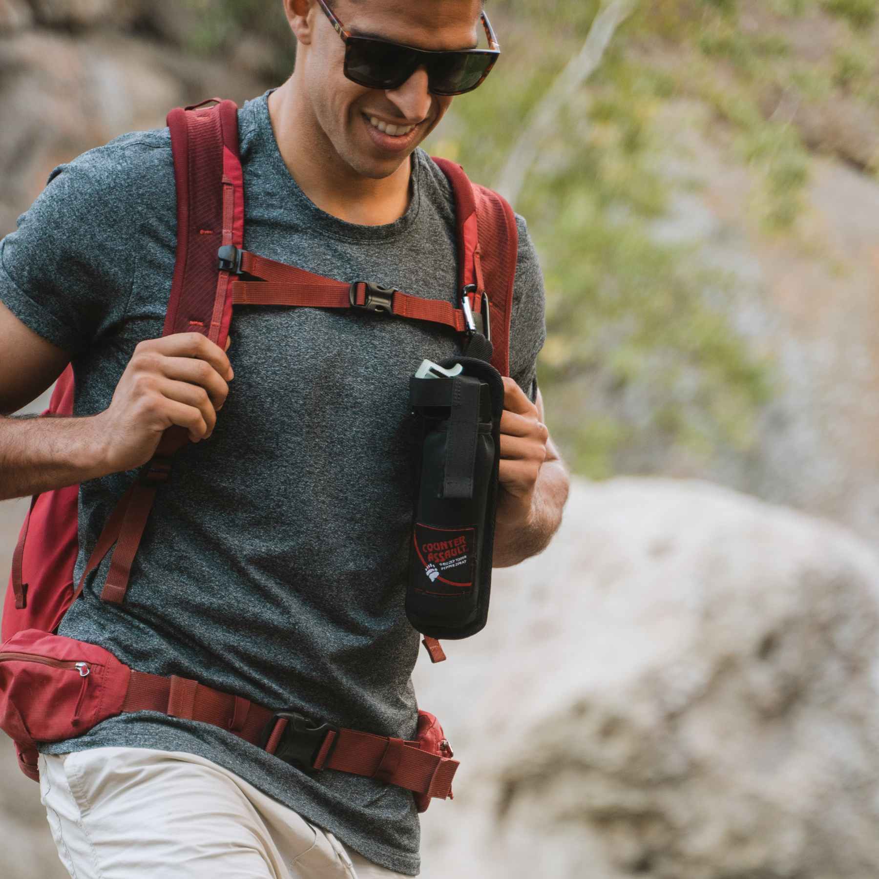 Man walking with a bear spray holster attached to bag