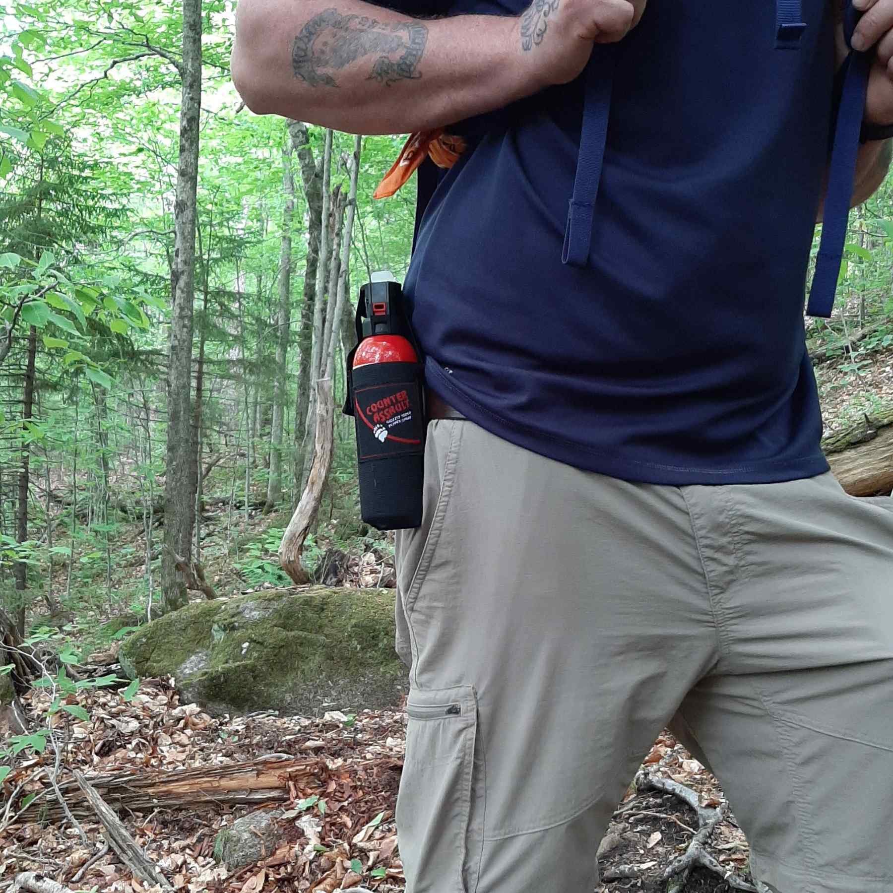 Man walking with a bear spray universal belt holster attached
