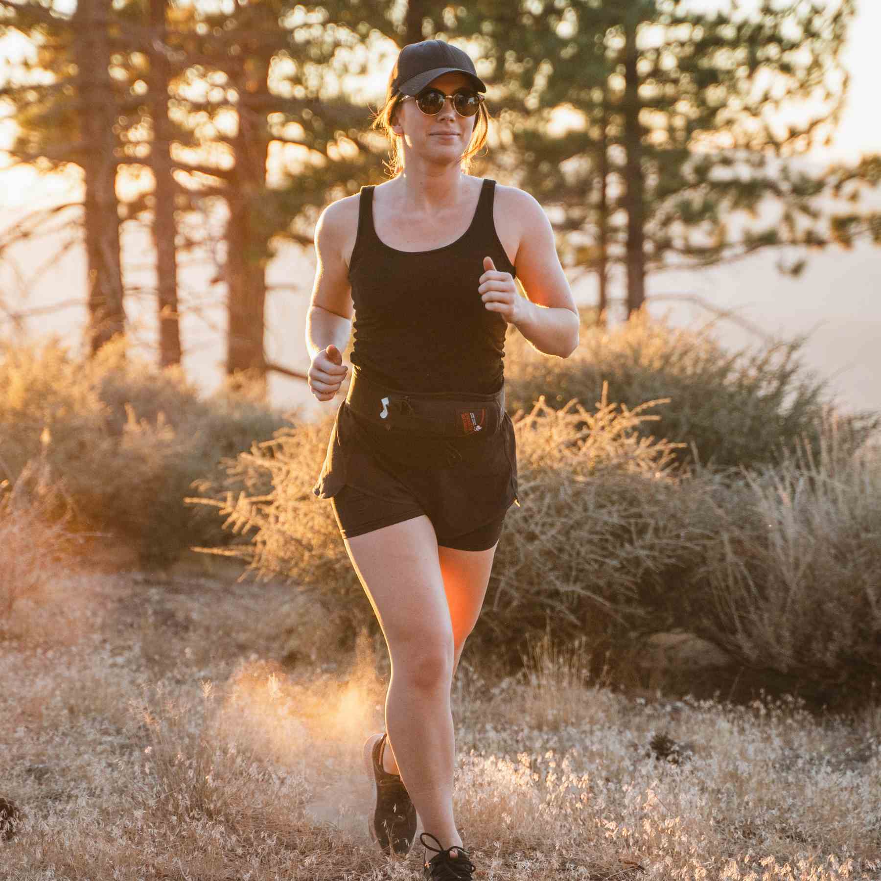 Woman running with a trail runner holster attached