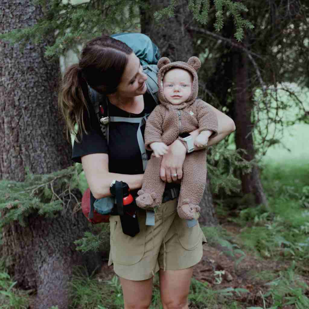 Mother with baby in a bear suit with bear spray in holster on her hip.