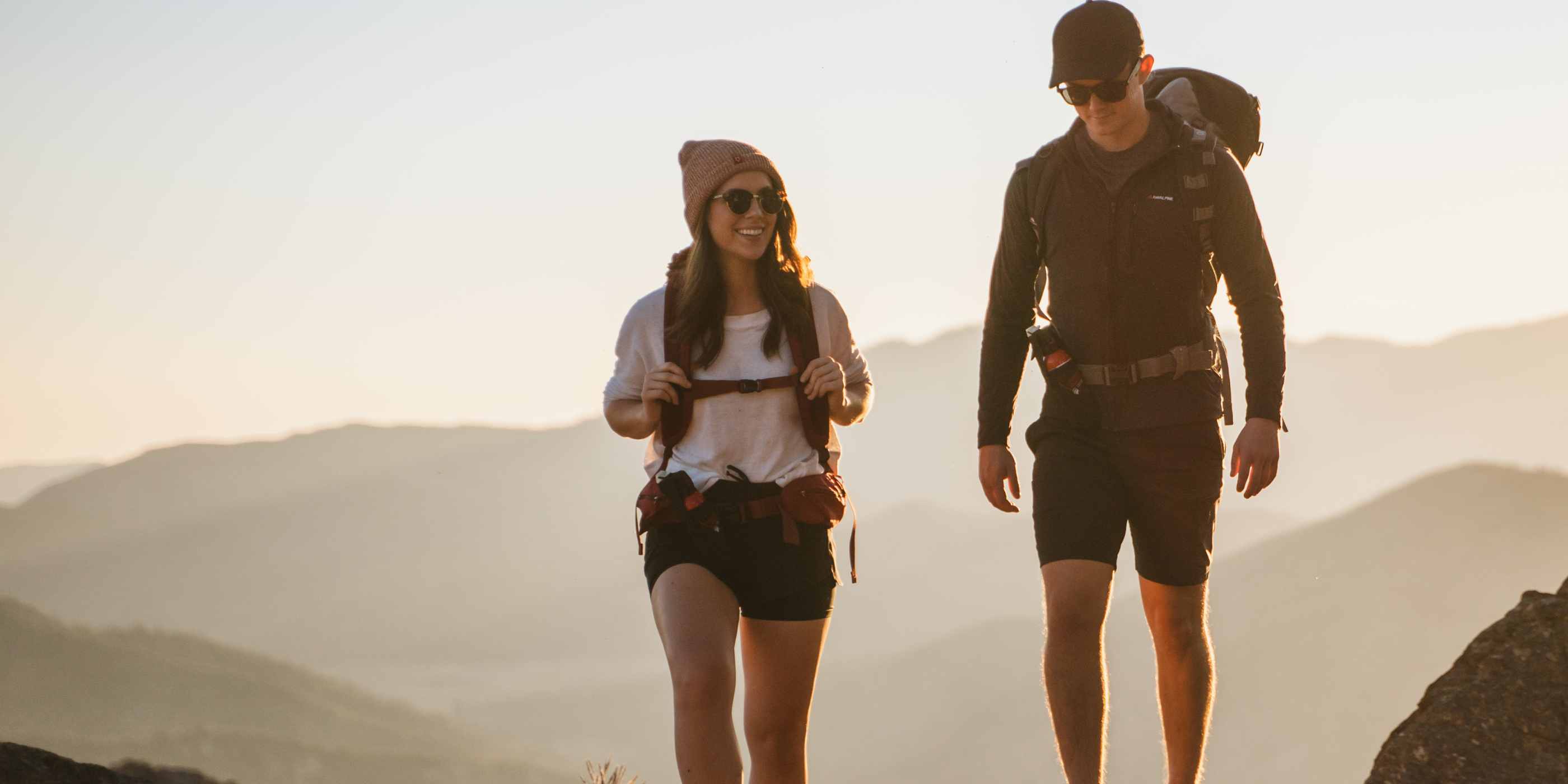 Two hikers carrying bear spray on their hips.